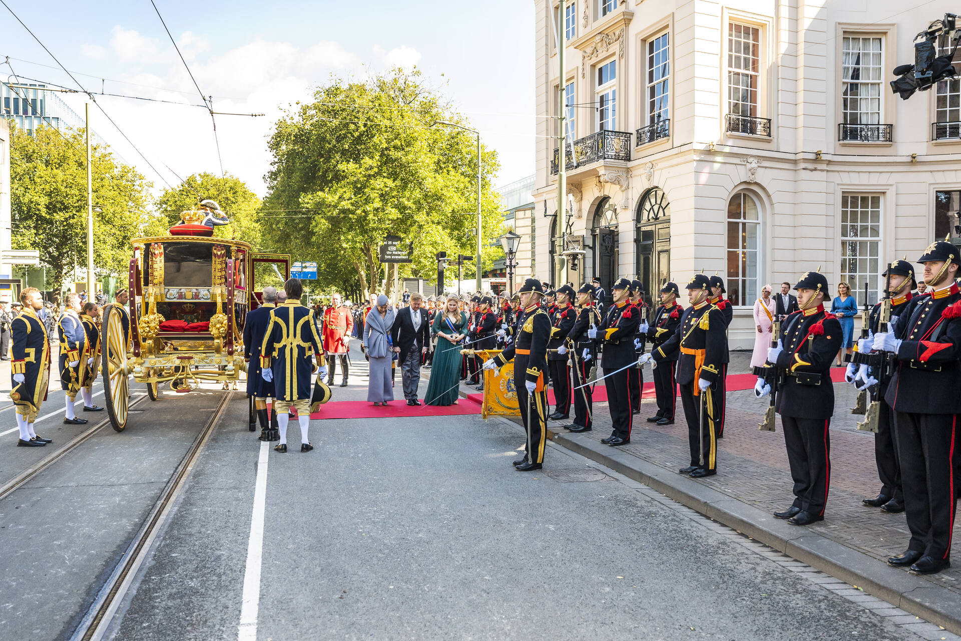 Koning, koningin en prinses van Oranje groeten het vaandel bij aankomst bij de Koninklijke Schouwburg op Prinsjesdag in 2022